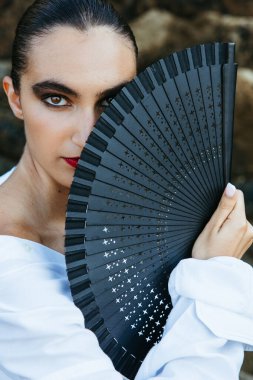 Dramatik bakışlı dansçı yüzünü vantilatörle kapatıyor