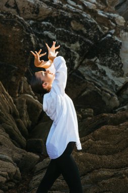 Flamenko dansçısı altın saatinde deniz kenarında zarif bir poz veriyor.