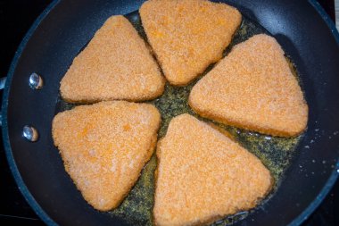 Ekmek kırıntıları içinde beş parça peynir kızartma tavasında bir oligi 'de kızartılır. Kızarmış patates.