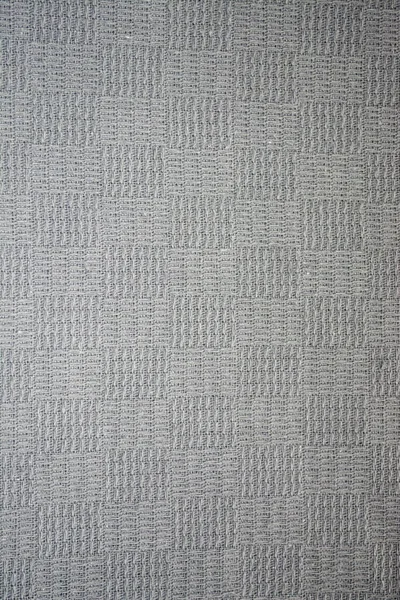 A gray knitted background in squares. Photo Gray knitted background. Square gray background. Background of solid gray knitwear in squares