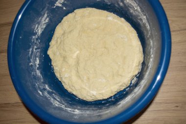 Mavi bir kasede bükülmüş fetal hamur. Doğum hamuru yapma sürecinin fotoğrafı. Doğum hamuru