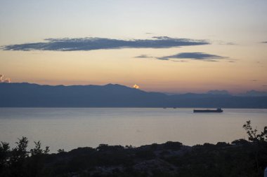 Dağın arkasındaki parlak ışık. Bu KRK Hırvatistan adasında gün batımı