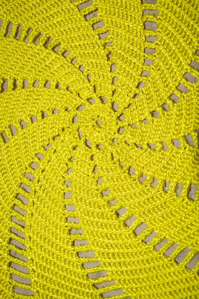 Yellow crocheted fabric. Crocheted fabric texture. Yellow cotton fabric