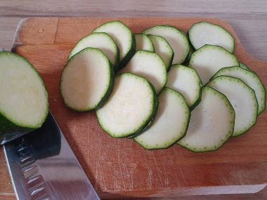 Kabak, tahta bir kesme tahtasıyla daireler çiziyor. Yemek pişirme süreci. Sebze kabağı daireler çiziyor.