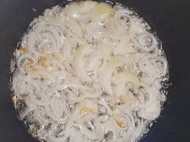 Doğranmış soğan kızartma tavasında kızartılır. Altın olana kadar kızartma tavasında soğan pişirme fotoğrafları.