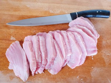 Ahşap bir tahtanın üzerinde çiğ domuz eti parçalara ayrılmış. Domuz eti pişirme işlemi. Etleri pirzolaya ya da Fransızcada ete hazırlamak