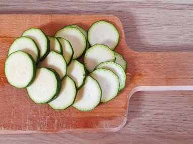 Kabak ahşap bir tahtanın üzerinde daireler çiziyor. Kabak pişirme süreci. Kabukta çiğ kabak.