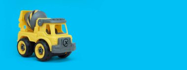 Sarı plastik karıştırıcı kamyon oyuncağı mavi arka planda izole edilmiş. İnşaat vechicle kamyonu. oyuncakçı pankartı için bir kopya alanı.