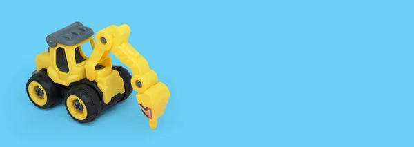 Жовта Пластикова Тракторна Іграшка Ізольована Синьому Фоні Копіювальним Простором Текстового — стокове фото