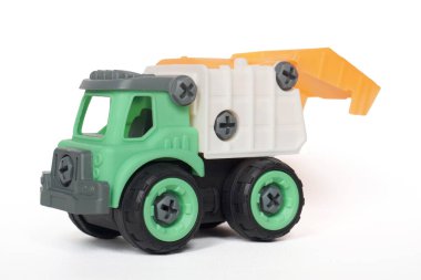Plastik kamyon oyuncağı beyaz arka planda izole edilmiş. İnşaat aracı kamyonu