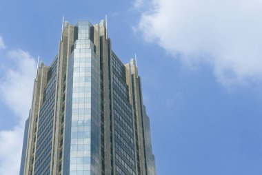 Modern ofis binaları mavi gökyüzüne karşı yükseliyor. Jakarta Endonezya ufuk çizgisi aşağıdan apartman, apartman ve ofis cepheleriyle görünüyor.