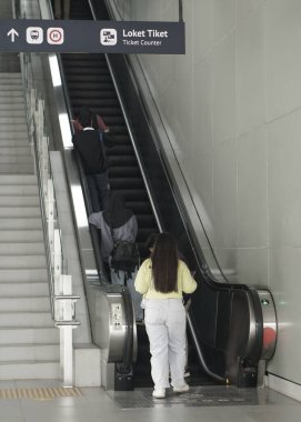 İnsanlar Jakarta, Endonezya 'daki Fatmawati MRT istasyonunda yürüyen merdivene biniyor. Jakarta Mass Rapid Transit (MRT) Endonezya 'nın ilk metro taşımacılığıdır..