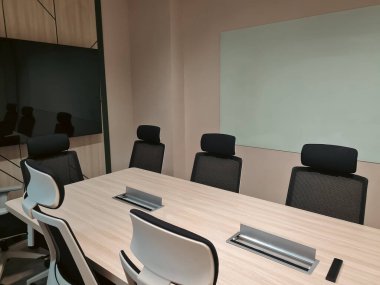 Televizyon ve beyaz panolu boş küçük toplantı odası. Modern minimalist iç mekan.
