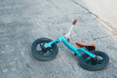 Yeşil Tosca itme motoru ya da dengeli bisiklet ya da beton zeminde terk edilmiş bisiklet. Toodler için bisiklet eğitimi.