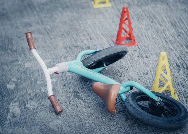 Beton zeminde terk edilmiş bisiklet ya da denge konileri. Toodler için güvenlik bisikleti eğitimi.