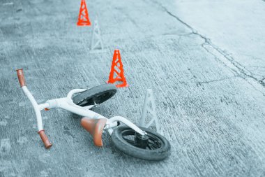 Beton zeminde terk edilmiş bisiklet ya da denge konileri. Toodler için güvenlik bisikleti eğitimi. izole edilmiş renk.