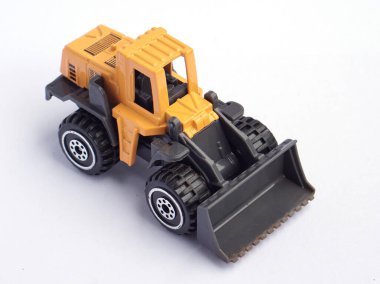 Beyaz arka planda izole edilmiş sarı oyuncak buldozerinin yüksek açılı görüntüsü, ağır makine modeli ya da diyabeti. En üstteki resim