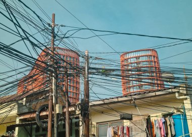 Dağınık elektrik kabloları, modern ofis binasına karşı karmaşık elektrik kabloları. Mahalle arasında açık bir boşluk