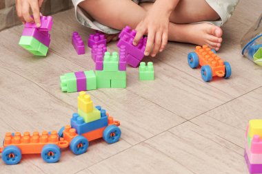 Bebek aktivitesi, renkli plastikle oynayan çocuk ya da oyuncak blokla bir şey inşa eden çocuk. Motorik aktivite. Çocuk gelişimi resim kavramı.