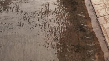 Şiddetli bir yağmurdan sonra ıslak beton zeminde çiselemeler, beton zemin boyunca akan yağmur suları....