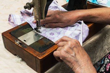  Eski bir dikiş makinesinde evde kumaş dikiyorum.