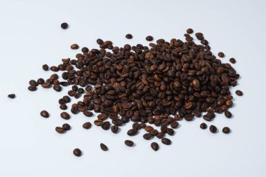 Beyaz arka planda izole edilmiş küçük bir kahve çekirdeği yığını. Canlılık ve iyi ruh hali kavramı.