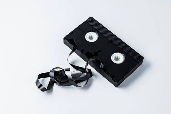 白い絶縁された背景の90年代からの古いビデオテープ 目に見える粉砕テープ — ストック写真