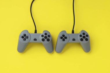 Oyun konsolu joystickleri parlak sarı bir arka planda izole edilir. Boş zaman konsepti