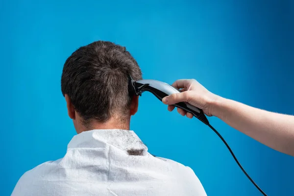 Cutting men\'s hair with an electric machine in simple home conditions. Isolated image