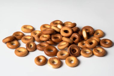 Beyaz arka planda izole edilmiş bir sürü simit. Çörekler beyaz arka planda izole edilmiş. Parlak çıtır çörekler. Çıtır kekler, un ürünleri..