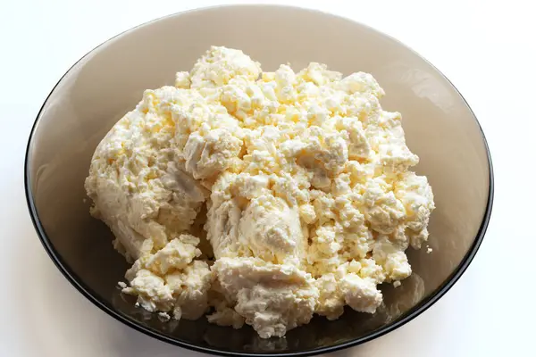 Beyaz arka planda doğal peynir püresi. Cam kasede kaymak peyniri. Üst Manzara. Yakın plan. Doğal yiyecek..