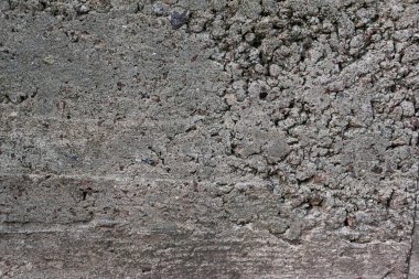 Çimento duvarı düzensizlikle dolu. Gri arkaplanı olan düzensiz desenli beton duvar.