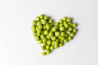 Beyaz arkaplanda taze yeşil bezelyeler.