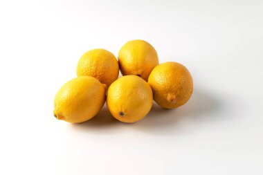 Beyaz arka planda olgun limonlar. Doğal C vitamini, limon yakın çekimi, taze meyve, sağlıklı beslenme, vitamin kaynakları.
