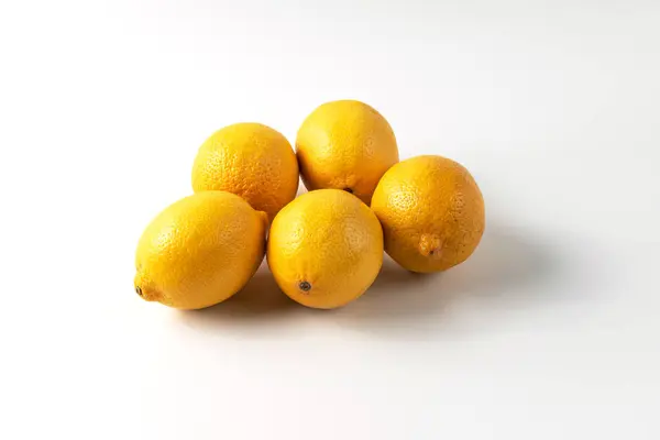 Beyaz arka planda olgun limonlar. Doğal C vitamini, limon yakın çekimi, taze meyve, sağlıklı beslenme, vitamin kaynakları.