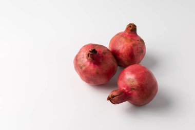 Three ripe pomegranates on a white background clipart