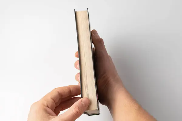 Eller kitabın yakın çekimini aç. Eğitim kavramı. Beyaz arka plan üzerine bir kitap tutan eller.
