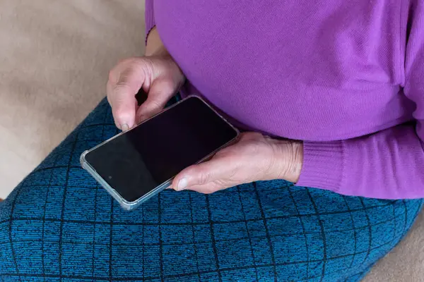 Akıllı telefonu yakın plan çeken yaşlı bir kadın..