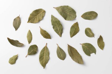 Kurumuş defne yaprakları beyaz arka planda izole edilmiş. Doğal çeşni. Yemek pişirmek için baharatlar, yakın çekim.