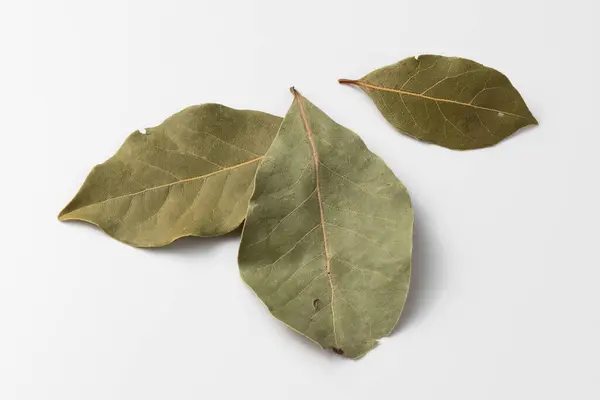 Kurumuş körfez yaprakları beyaz arka planda izole edilmiş. Doğal çeşni. Yemek pişirmek için baharatlar, yakın çekim.