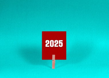 2025 Sembol. Kızıl Meydan Kağıdı 2025 'teki kavramsal kelimeler Tahta Mandal Manşet Yeşil Arkaplan tarafından tutuluyor. Kopya Alanı ile İş 2025 Kavramı.