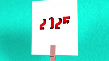 İnce Metin Animasyonlu 2025 Sembolü. 2025 Güzel Beyaz Kare Kağıt Üzerinde Metin Tahta Çamaşır iğnesi ile tutulan, Yeşil Çizelge Kağıt Arkaplan
