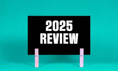 2025 REViEW Sembolü. Kara Dikdörtgen Kağıt üzerinde 2025 sayılı kavramsal sözcükler Tahta Clothespin Green Background tarafından tutulur. İş 2025 Yeniden İzleme Uzayı Kopyalama Konsepti