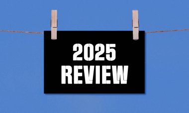 2025 REViEW Sembolü. Kara Dikdörtgen Kağıt üzerinde 2025 sayılı kavramsal sözcükler Tahta Çamaşır Mandalı Mavi Arkaplanda Asılı. İş 2025 Yeniden İzleme Uzayı Kopyalama Konsepti