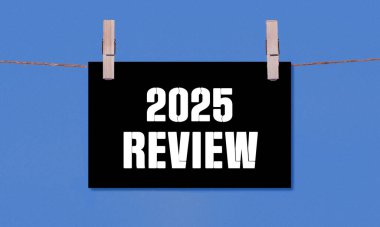 2025 REVIEW Symbol. Concept words 2025 REVIEW on Black Rectangle Paper Hanging on a Wooden Clothespin Blue Background. Business 2025 REVIEW Concept with Copy Space clipart