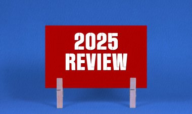 2025 REViEW Sembolü. Sözcükler 2025 Kırmızı Dikdörtgen Kağıt üzerinde Mavi Mandal Arkaplan tarafından tutulan. İş 2025 Yeniden İzleme Uzayı Kopyalama Konsepti