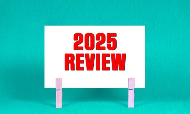 2025 REViEW Sembolü. Sözcükler 2025 Beyaz Dikdörtgen Kağıt üzerinde Tahta Clothespin Yeşil Arkaplan tarafından tutulan. İş 2025 Yeniden İzleme Uzayı Kopyalama Konsepti