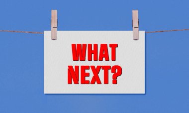 Ne Sonraki Sembol. Beyaz Dikdörtgen Kağıt 'ta Sırada Ne Var, kavramsal sözcükler Tahta Elbise Mandalı Mavi Arkaplanda Asılı. Kopyalama Alanı ile Sonraki Konsept