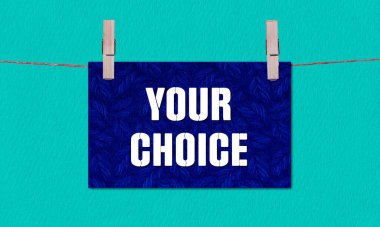 Your Choice Symbol. Concept words Your Choice on Dark Blue Rectangle Paper Hanging on a Wooden Clothespin Green Background. Business Your Choice Concept with Copy Space clipart