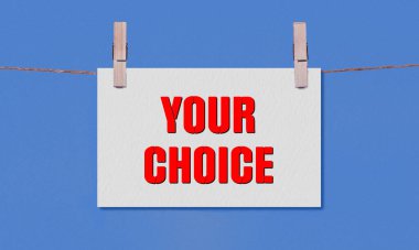 Your Choice Symbol. Concept words Your Choice on White Rectangle Paper Hanging on a Wooden Clothespin Blue Background. Business Your Choice Concept with Copy Space clipart